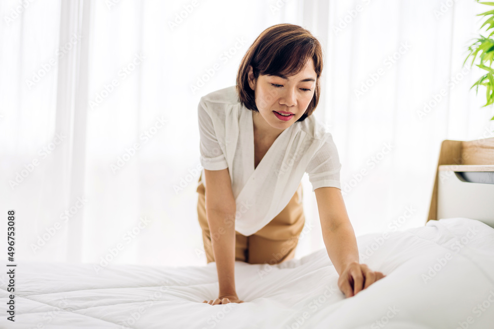 Young asian woman housewife clean bed and set up changing bedsheet with white clean sheet tidy up bedroom.room service and cleaning concept Young asian woman housewife clean bed and set up changing bedsheet with white clean sheet tidy up bedroom.room service and cleaning concept