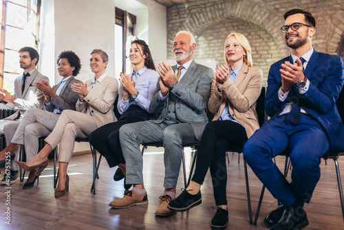 Happy business team applauding after successful group meeting