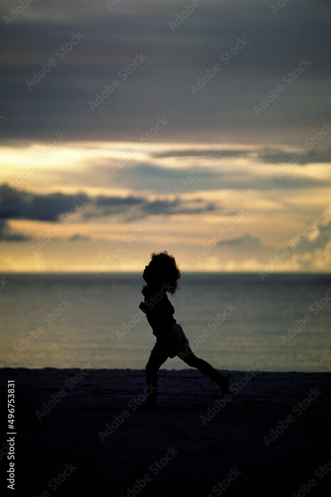 浜辺を走る子供　海辺で遊ぶ子供　シルエット　黄昏の海