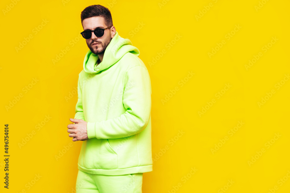 Portrait of handsome confident model. Sexy stylish man dressed in yellow hoodie with no logo. Clothes branding mockup. Design template for casual sportswear. Fashion male isolated in studio Portrait of handsome confident model. Sexy stylish man dressed in yellow hoodie with no logo. Clothes branding mockup. Design template for casual sportswear. Fashion male isolated in studio