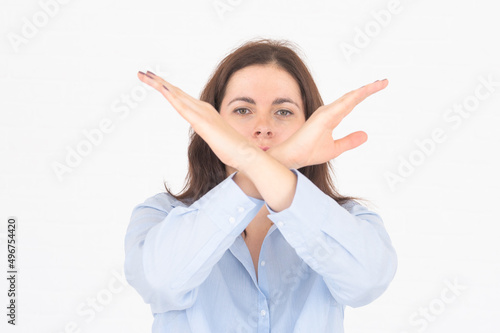 Young woman showing stop by hands, keeps palms outstretches, makes refusal gesture, rejects offer on white backround