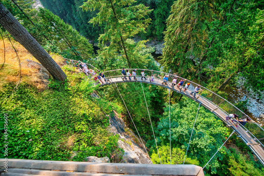 Fototapeta premium Vancouver, Canada - August 11, 2017: People at Capilano Bridge. It is a Suspension bridge crossing the Capilano River, 140 metres long and 70 metres above the river.