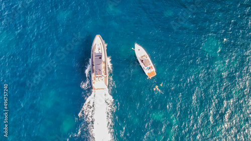 Overhead aerial view of speedboats near the shoreline.