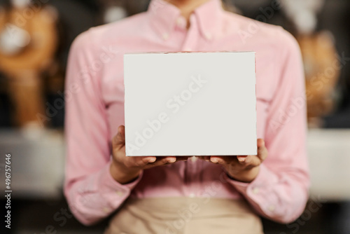 Barista's hands holding a box.
