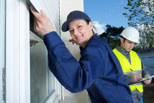 female contractor installing window shutter