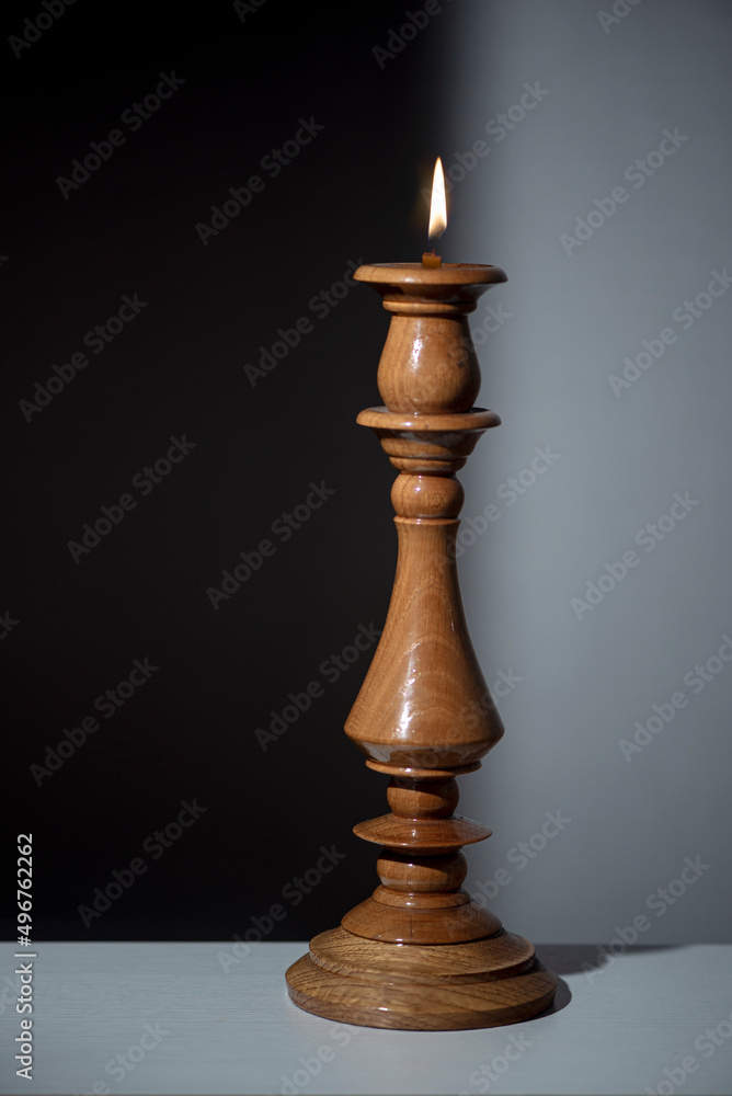 Wooden candlestick. Black and white in the reflection of a candle. Wooden candlestick. Black and white in the reflection of a candle.