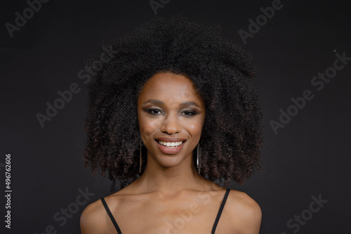 Smiling beautiful young woman against black background