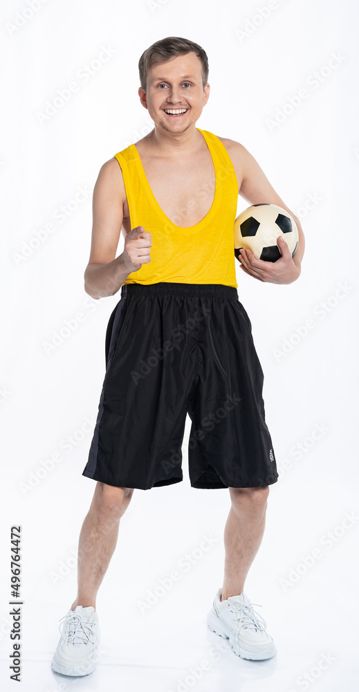 fitness man with a thin body, an athlete in black shorts and a yellow t-shirt holds a soccer ball. The concept of sports motivation for training. fitness man with a thin body, an athlete in black shorts and a yellow t-shirt holds a soccer ball. The concept of sports motivation for training.
