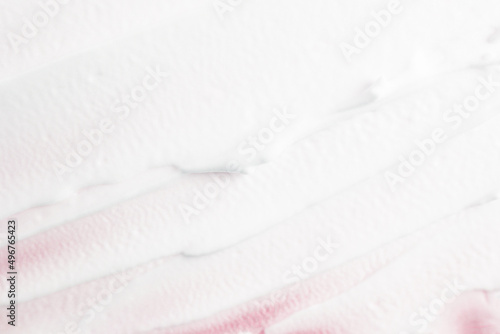 White face cream applied on a pink background. Cosmetic product for skin care  lotion. Texture strokes top view.