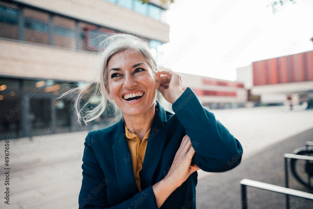 © Westend61 - Cheerful businesswoman with hand in hair at office park