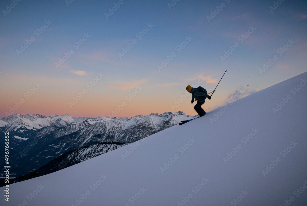 Man skiing on snowcapped mountain at sunset Man skiing on snowcapped mountain at sunset