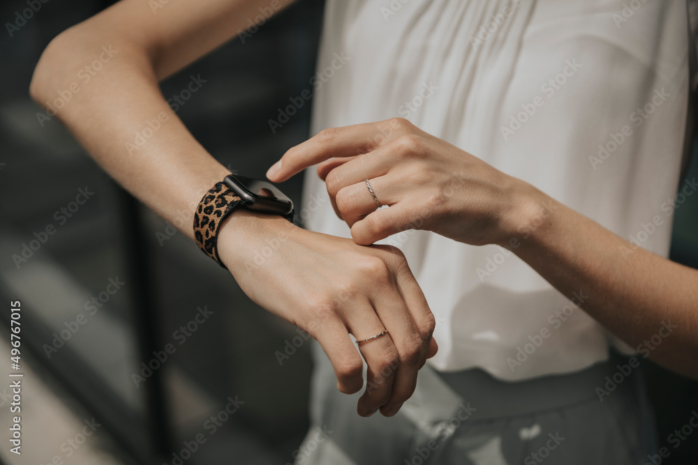Young woman touching smart watch on sunny day Young woman touching smart watch on sunny day