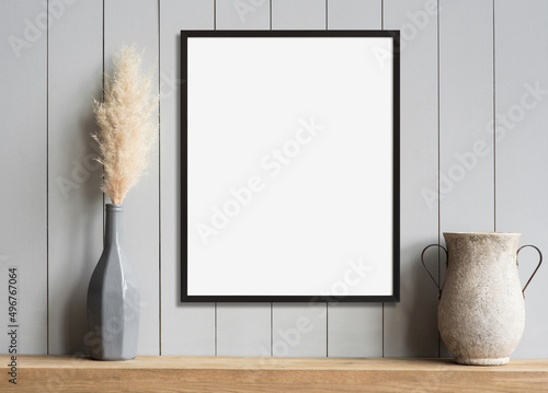 Blank picture frame mockup on gray wall. White living room design. View of modern scandinavian style interior with artwork mock up on wall. Home staging and minimalism concept