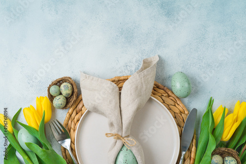 Canvas Print Easter festive table setting with easter eggs decoration and yellow tulips flowers on gray background