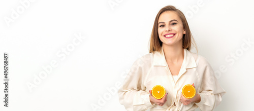 Young Caucasian smiling woman holding slices orange over isolated white background, breast health concept photo