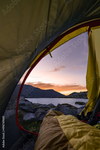 Person inside a sleeping bag with feet outside the tent