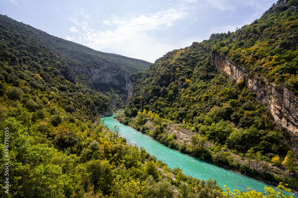 Deep turquoise river at the bottom of a vertical canyon