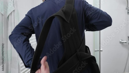 Headless businessman in bathroom put on orthopedic posture belt over elegant blue shirt 4K photo