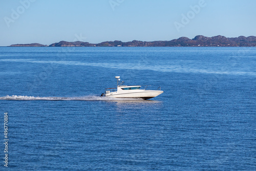 Fast white motor boat sails Norwegian Sea