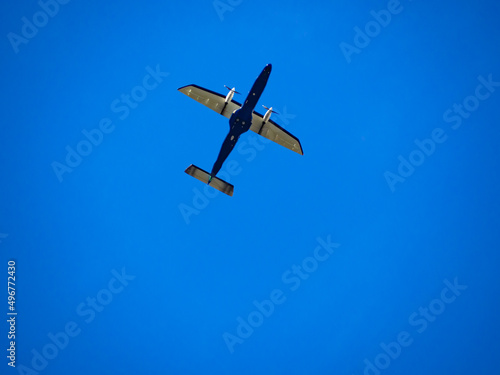 青空を悠々と飛ぶ小型飛行機