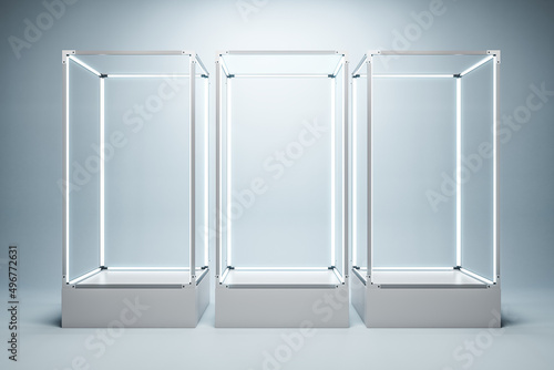 Fotografija Empty illuminated glass showcase with mock up place on white wall backdrop