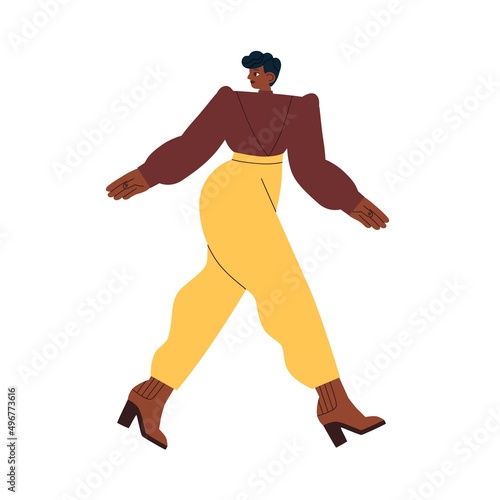 Modern black woman walking in fashion outfit, wearing elegant blouse and trou...