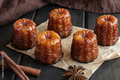 Local French dessert canele on a dark wooden background