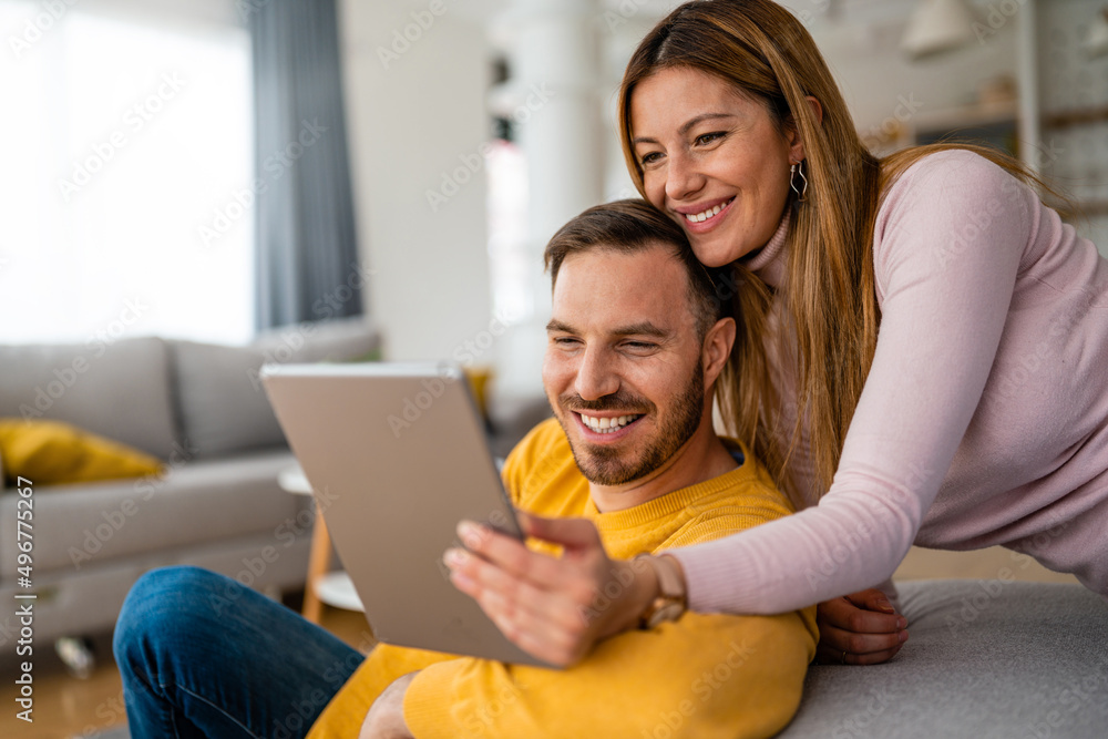 Young couple at home websurfing on tablet, internet Young couple at home websurfing on tablet, internet