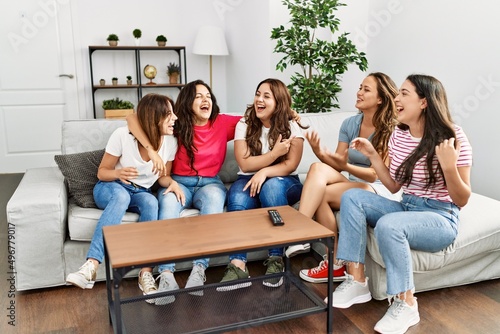 Group of young women friends smiling happy sitting on the sofa at home.