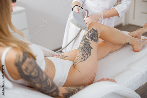 Beautician performing laser hair removal procedure in beauty salon photo