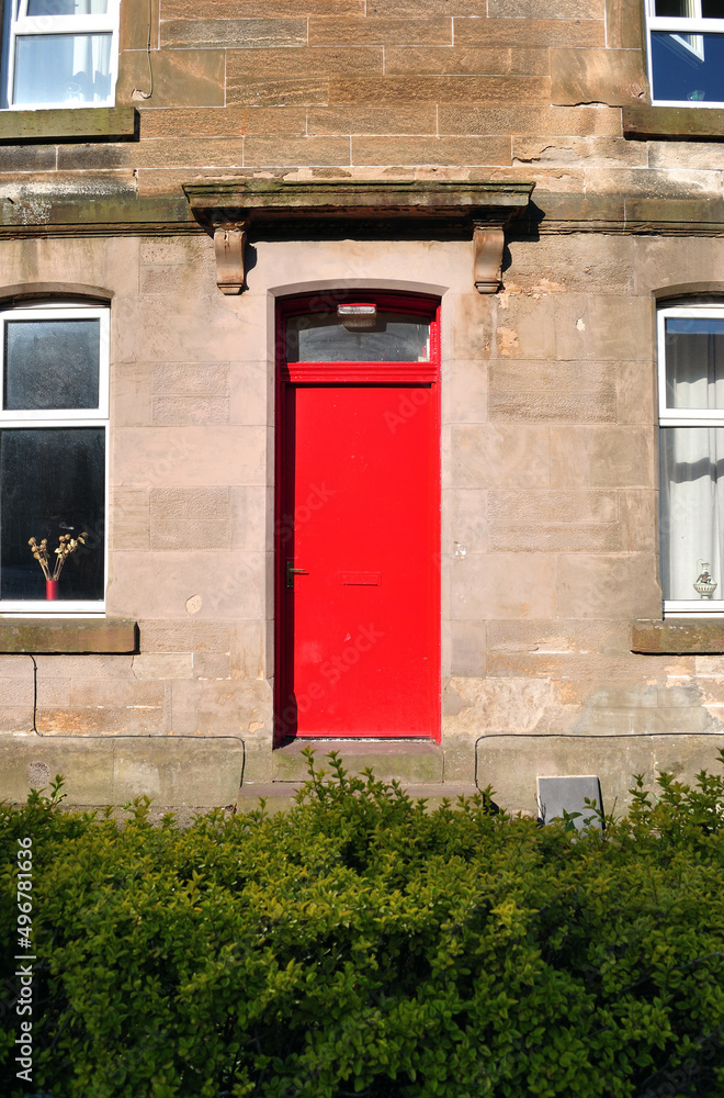 Naklejka premium Red Painted Entrance Door to Old Stone Building 