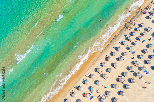 Top view aerial drone photo of Banana beach with beautiful turquoise water, sea waves and straw umbrellas. Vacation travel background. Ionian sea, Zakynthos Island, Greece