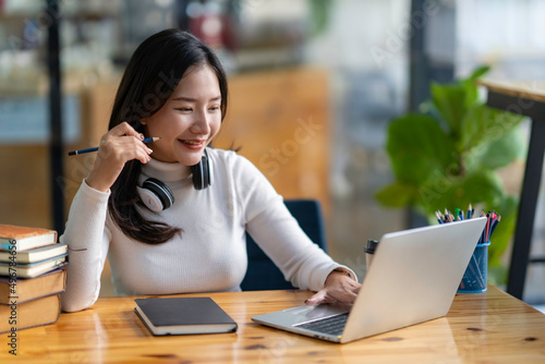 Photography study abroad happy asian girl laughing While doing homework, make a video call abroad using a friend's internet connection