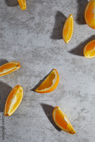 Two-quarter slices of orange without leaves on gray background. Healthy snack, organic food. Top view with copy space.
