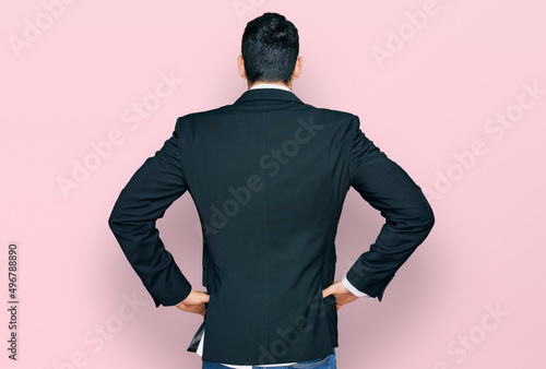 Konstfotografi Handsome hispanic man wearing business clothes standing backwards looking away w