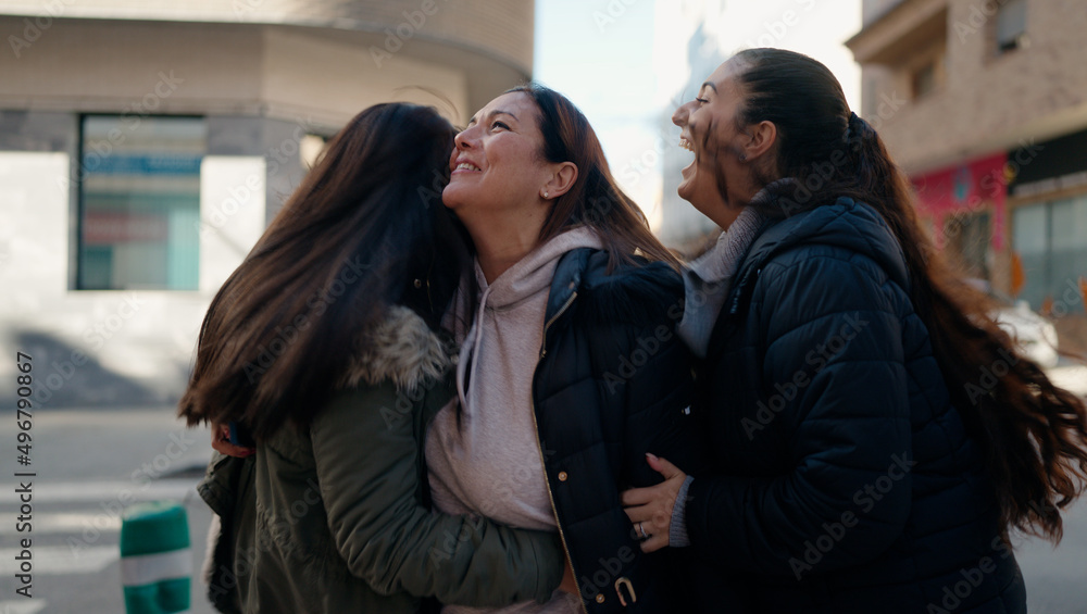 Mother and daugthers smiling confident hugging each other at street Mother and daugthers smiling confident hugging each other at street