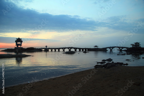 Beautiful scenery of the bridge at the beach during sunset in Xingcheng, China photo