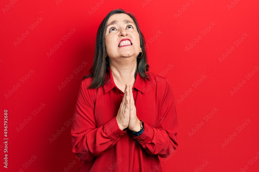 Middle age hispanic woman wearing casual clothes begging and praying with hands together with hope expression on face very emotional and worried. begging. Middle age hispanic woman wearing casual clothes begging and praying with hands together with hope expression on face very emotional and worried. begging.