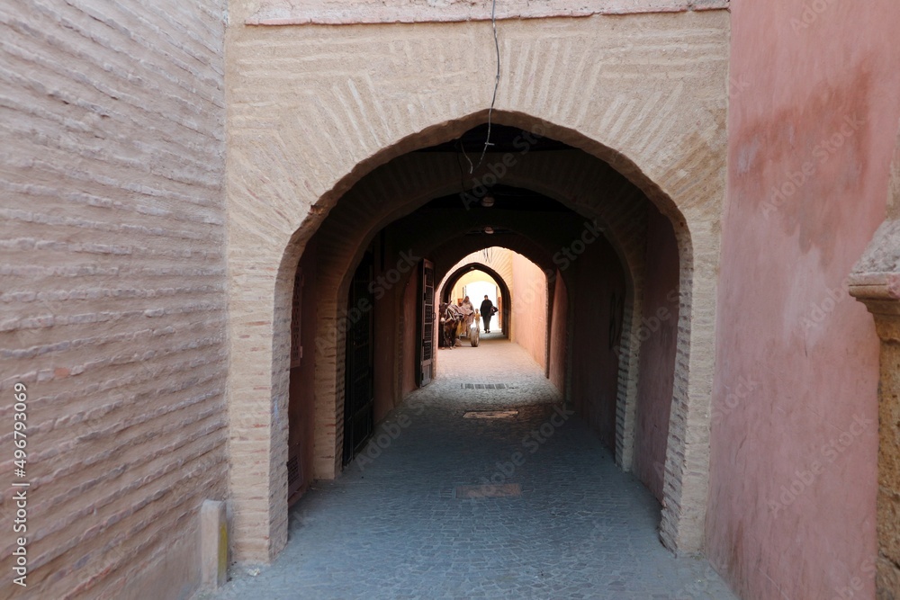 Ancient alley with stone arch in medina of Marrakesh (Morocco)