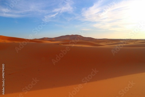 Shadows in the sand dunes of Erg Chebbi desert during golden hour at sunset in Morcco