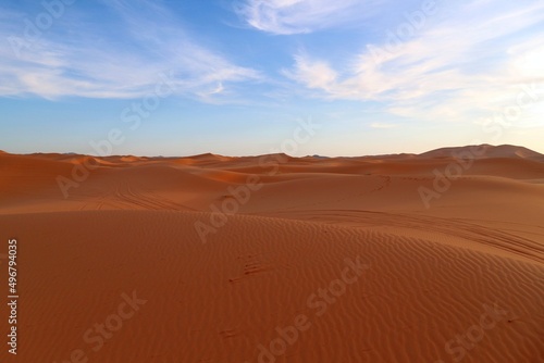 Shadows in the sand dunes of Erg Chebbi desert during golden hour at sunset in Morcco