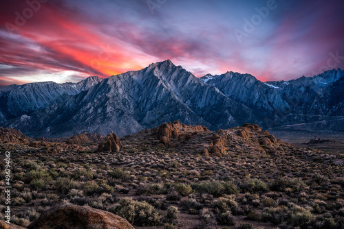 Beautiful view of sunset over the snow covered Alabama hills with rocky field in front