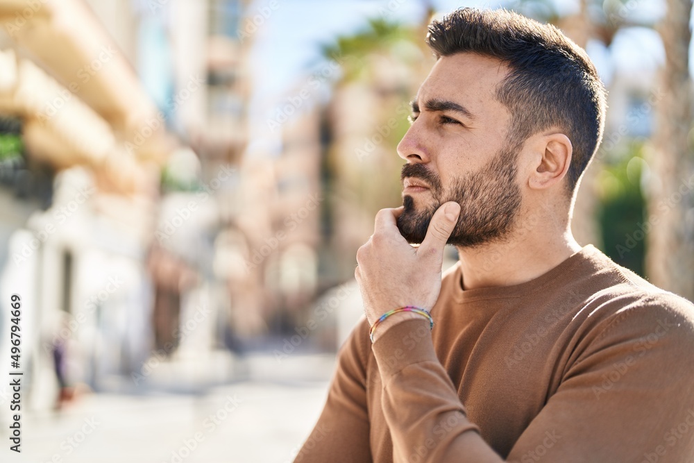 Young hispanic man standing with doubt expression at street Young hispanic man standing with doubt expression at street