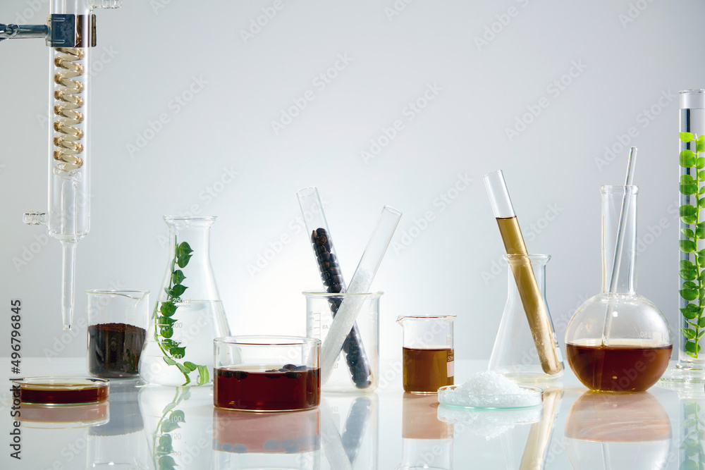 A front view of coffee extract decorated with laboratory equipment in white lab background A front view of coffee extract decorated with laboratory equipment in white lab background