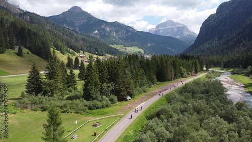 Val di Fassa (Fassa Valley) at Trentino, Dolomites, Italy - Aerial Drone View of Cycling Tourists and Green Mountain Valley photo