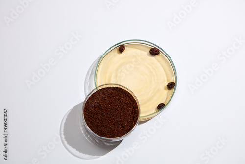 Closeup view of coffee extract decorated with petri dish with laboratory equipment in white background 