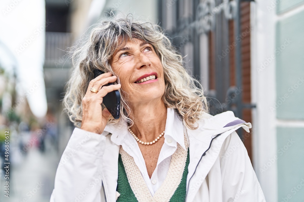 Middle age woman smiling confident talking on the smartphone at street Middle age woman smiling confident talking on the smartphone at street