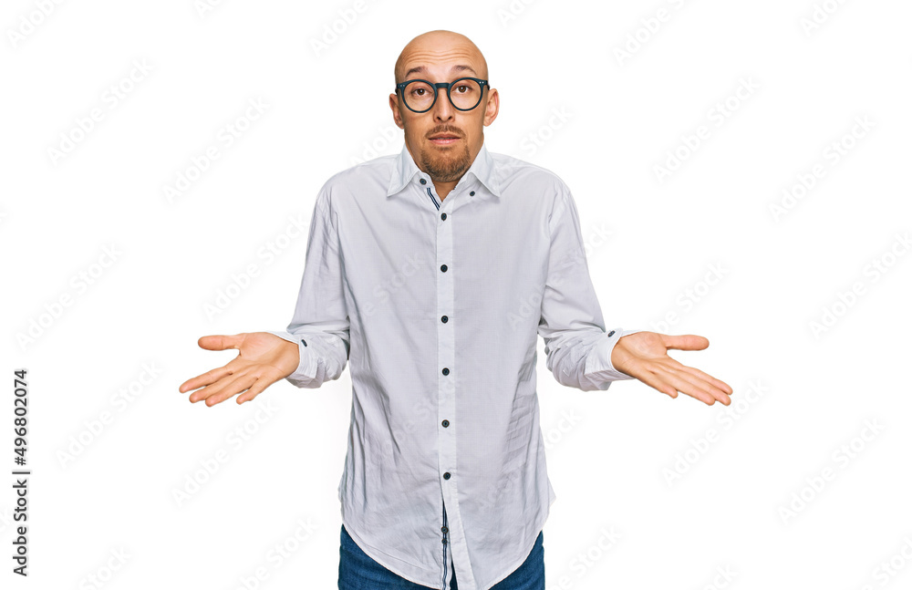 Bald man with beard wearing business shirt and glasses clueless and confused expression with arms and hands raised. doubt concept. Bald man with beard wearing business shirt and glasses clueless and confused expression with arms and hands raised. doubt concept.