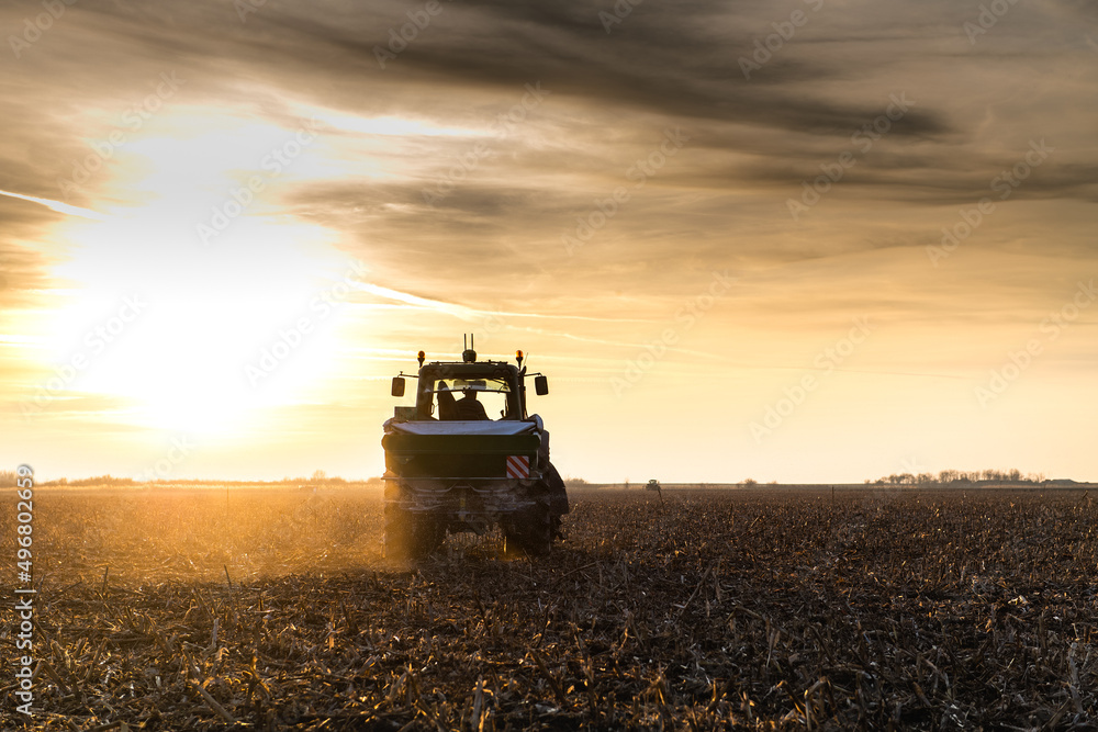 Fototapeta premium Tractor spreading artificial fertilizers in field