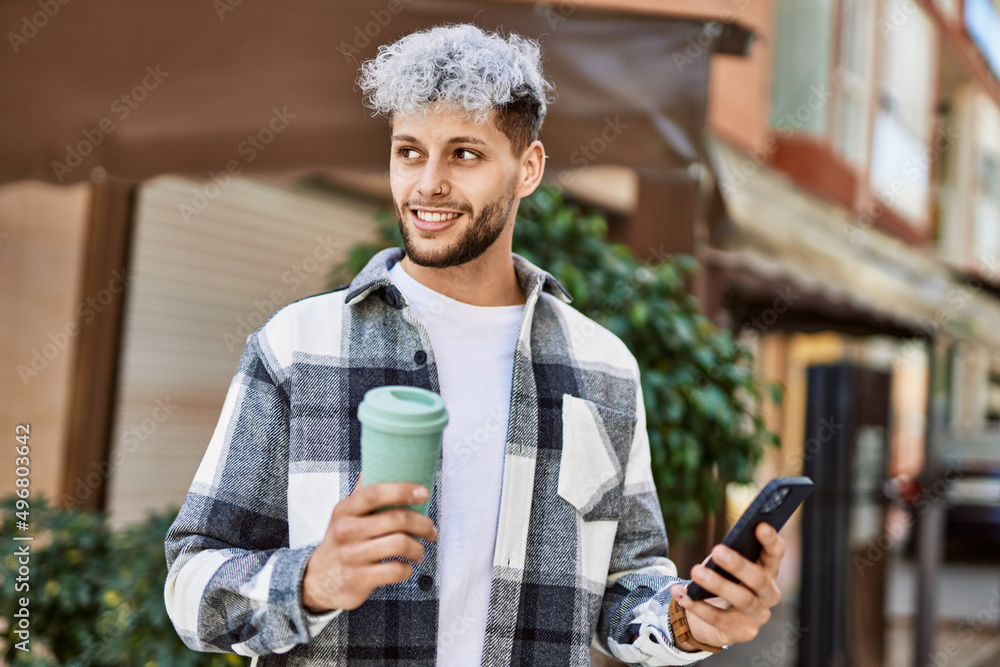 Young hispanic man smiling happy using smartphone at the city. Young hispanic man smiling happy using smartphone at the city.